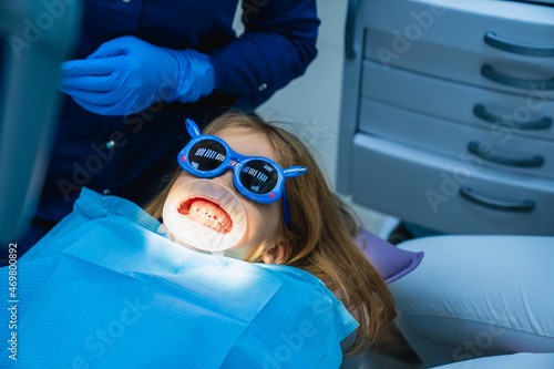 kid girl with oral dilator at dentist's appointment. treatment of teeth photo