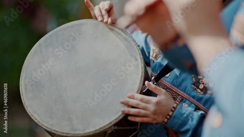 Armenian boy drummer's hands playing dhol drum in traditional armenian wear during the harvest festival photo