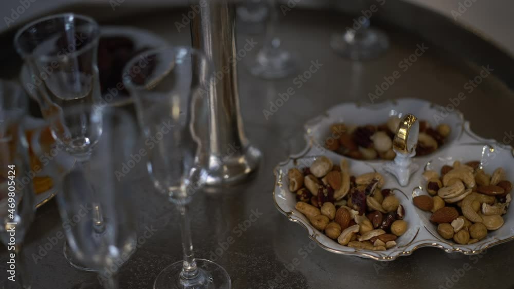 Close-up nuts and champagne glasses on table indoors. Snacks and drinks on luxurious party. Celebration and leisure concept Close-up nuts and champagne glasses on table indoors. Snacks and drinks on luxurious party. Celebration and leisure concept