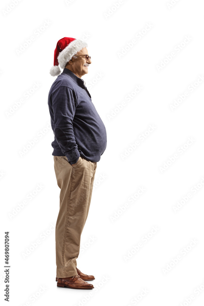 Full length profile shot of a mature man wearing a santa claus hat Full length profile shot of a mature man wearing a santa claus hat