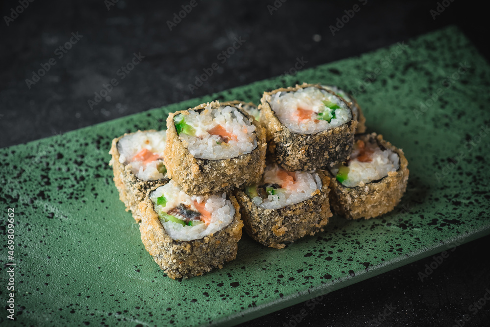 hot sushi roll on a black plate hot sushi roll on a black plate