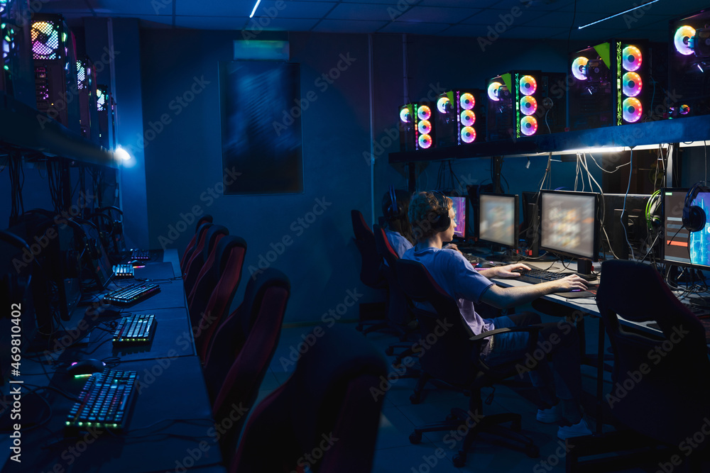 Diverse gamers sitting at the computers while participating in eSports tournament Diverse gamers sitting at the computers while participating in eSports tournament