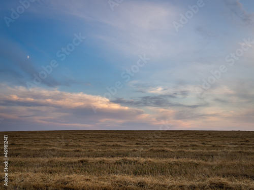 Autumn field and dark evening clouds.