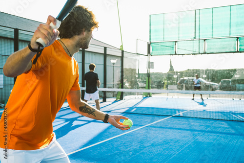 Mixed padel match in a blue grass padel court - .Beautiful girl and handsome man playing padel outdoor