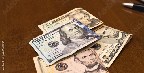 Notas de Dólares do Estados Unidos sobre uma mesa de madeira em fotografia com vista de perto. Economia e finanças.