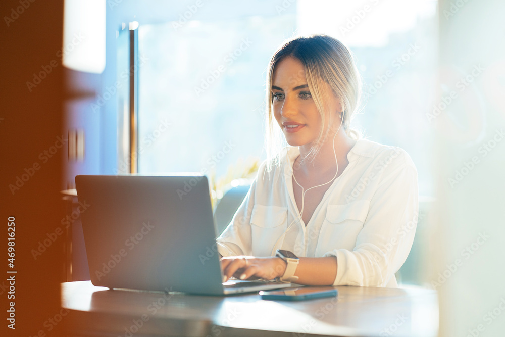 Stylish businesswoman typing on laptop in cafe Stylish businesswoman typing on laptop in cafe