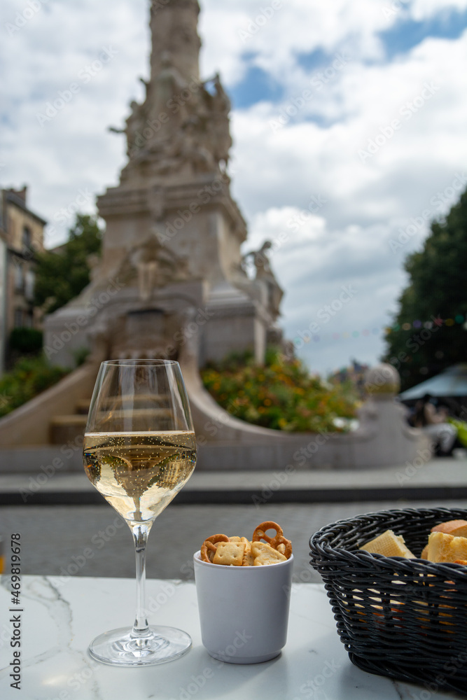 Drinking of brut champagne sparkling wine in street cafe in old central part of city Reims, Champagne, France
