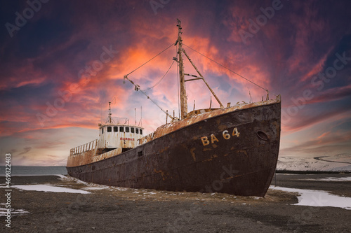 old boat stranded on nordic beach in winter photo