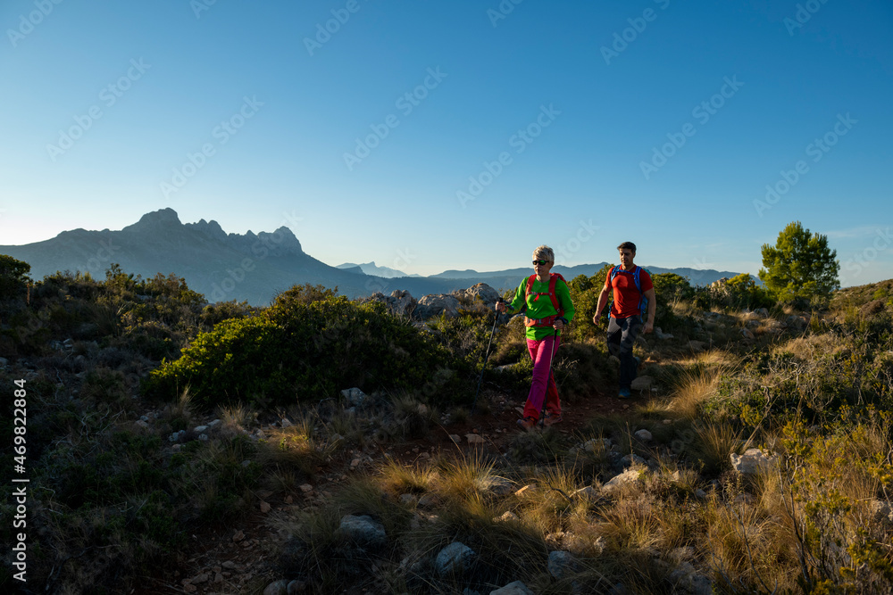 Couple hiking on Oltá mountain, Calpe, Alicante, Spain Couple hiking on Oltá mountain, Calpe, Alicante, Spain
