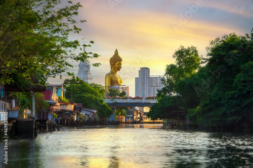 Big golden buddha statue under construction at Wat Paknam Bhasicharoen temple at sunset, in Bangkok, Thailand photo