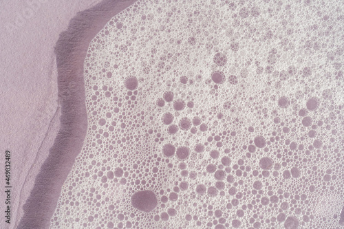 Texture of white foam on a purple background.