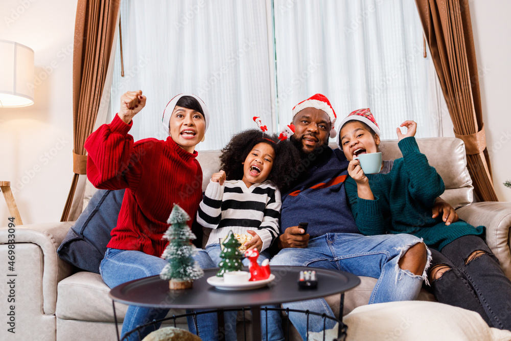 African American family in Christmas theme. Happy family has fun sitting together on the sofa at home. cheerful young family with children laughing. African American family