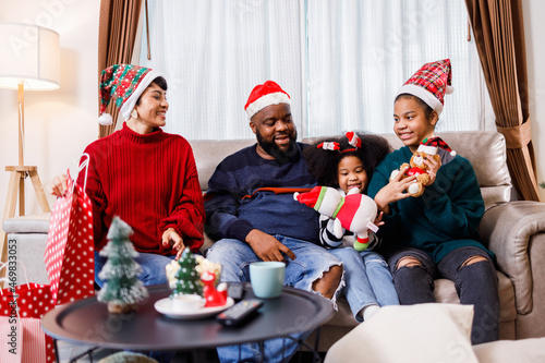 African American family surprised with a gift on Christmas day. Merry Christmas. African American family in Christmas theme