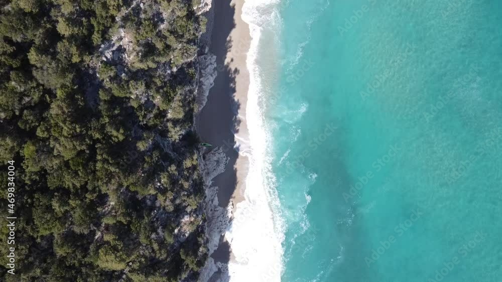 Sardinian sandy beach with rocks and forest from above, waves breaking in front of a cave (Cala Luna) Sardinian sandy beach with rocks and forest from above, waves breaking in front of a cave (Cala Luna)