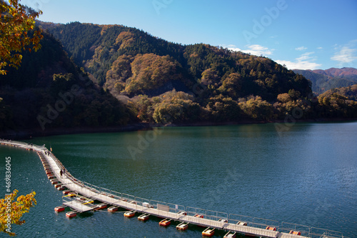 Photography Floating bridge made of drum containers in a blue lake in Okutama, Japan, sunny