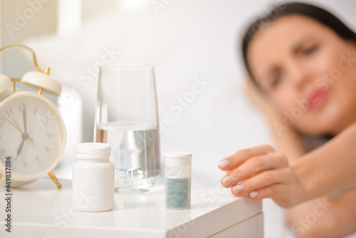 Sick woman taking pills at ...