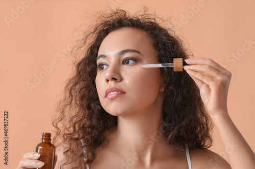Young woman applying facial...