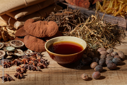 Fotografie Traditional chinese medicine with herb and spices in brown wooden background mor