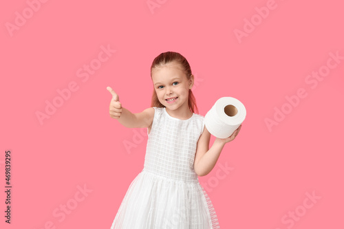 Little girl with toilet paper showing thumb-up on color background