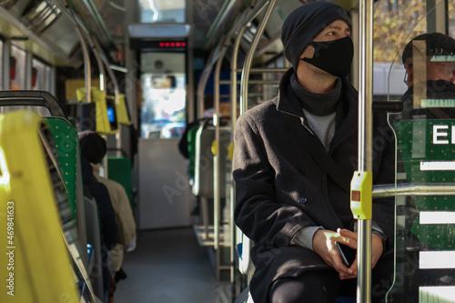 European man in a face mask traveling in public transport. Safety precautions
