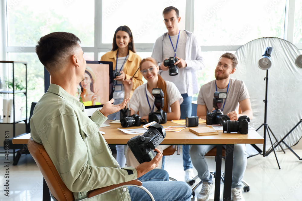 Professional photographer teaching young people in studio Professional photographer teaching young people in studio