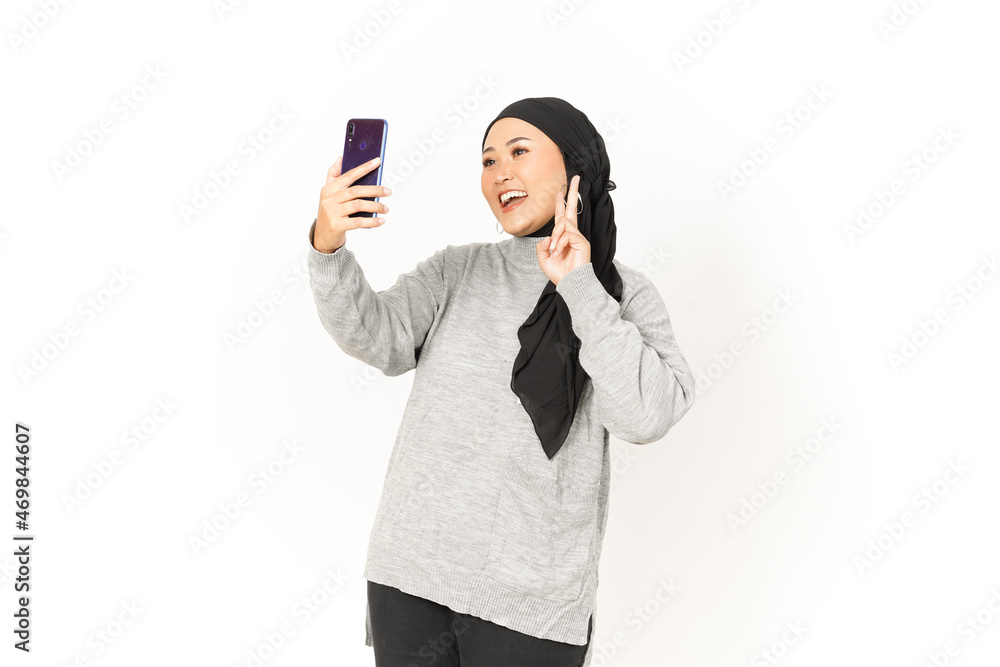 Take A Selfie using smartphone of Beautiful Asian Woman Wearing Hijab Isolated On White Background Take A Selfie using smartphone of Beautiful Asian Woman Wearing Hijab Isolated On White Background