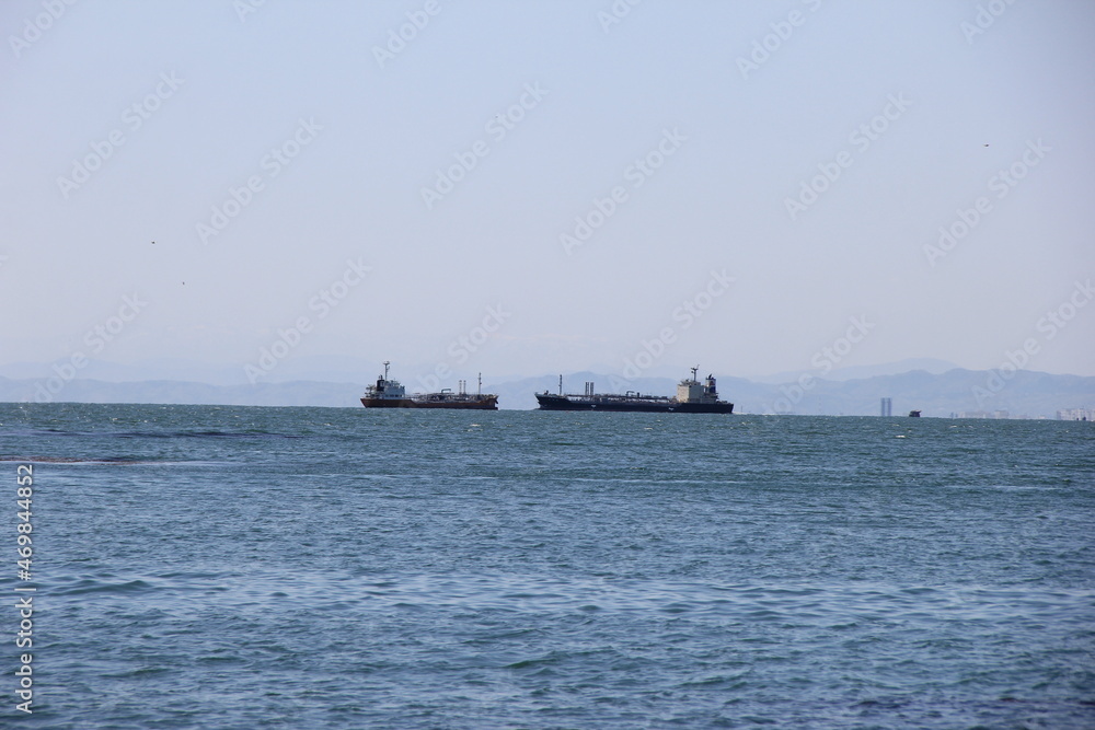 沖に大きな船が２艘並んでいる海の風景