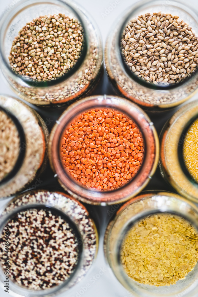red lentils and other healthy whole grains and legumes in clear pantry jars on marble background, simple ingredients concept red lentils and other healthy whole grains and legumes in clear pantry jars on marble background, simple ingredients concept