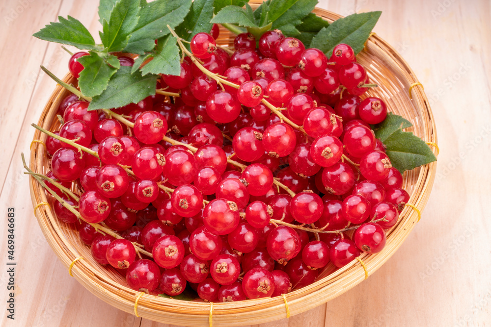 Table top view bunch of red currant in basket, Red currant berries with leaf on wooden table. Table top view bunch of red currant in basket, Red currant berries with leaf on wooden table.