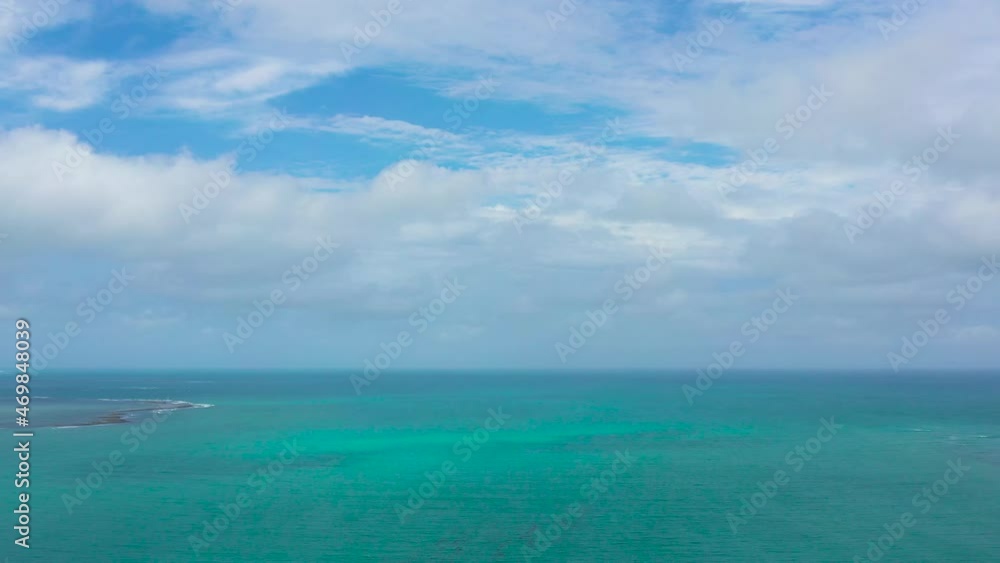 Sea surface with waves against the blue sky with clouds. Top view transparent turquoise ocean water surface. background texture Sea surface with waves against the blue sky with clouds. Top view transparent turquoise ocean water surface. background texture