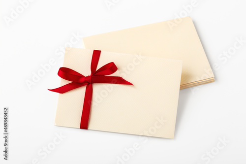 Letter with red bow ribbon on stack of envelope, mockup