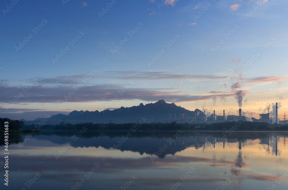 Coal power plant and water reflection in the morning among the mountains and lakes. Mae Moh, Lampang, Thailand.