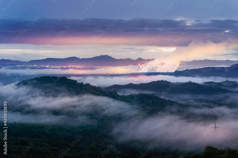 Aerial view mist after the rain on the mountain high voltage pole and steam from a coal power plant at sunset, Pang Puey, Mae Moh, Lampang, Thailand. Energy and environment concept. Long exposure.
