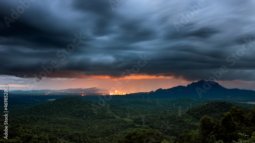 Aerial view mist after the rain on the mountain high voltage pole and steam from a coal power plant at sunset, Pang Puey, Mae Moh, Lampang, Thailand. Energy and environment concept. Long exposure. 