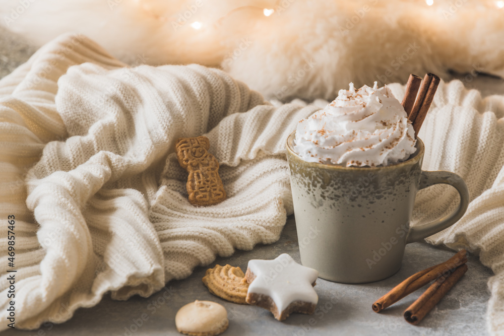 Gray cup of coffee or hot chocolate with cream, cinnamon and christmas cookies, fairy light in the background Gray cup of coffee or hot chocolate with cream, cinnamon and christmas cookies, fairy light in the background