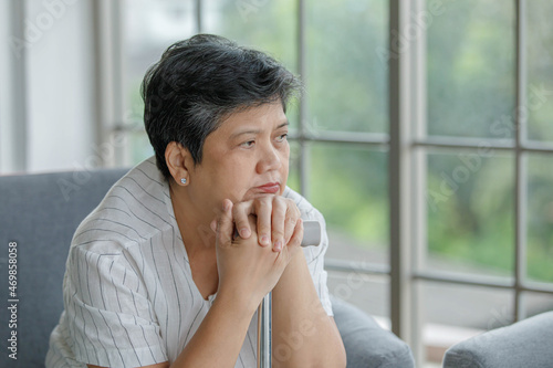 Bored mature woman leaning on cane