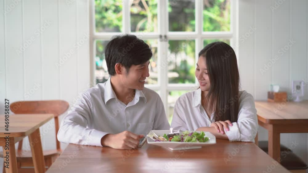 Happy couple posing taking selfie together use smartphone enjoying romantic date at restaurant. Smiling man and woman photographing on mobile enjoying their lunch Happy couple posing taking selfie together use smartphone enjoying romantic date at restaurant. Smiling man and woman photographing on mobile enjoying their lunch