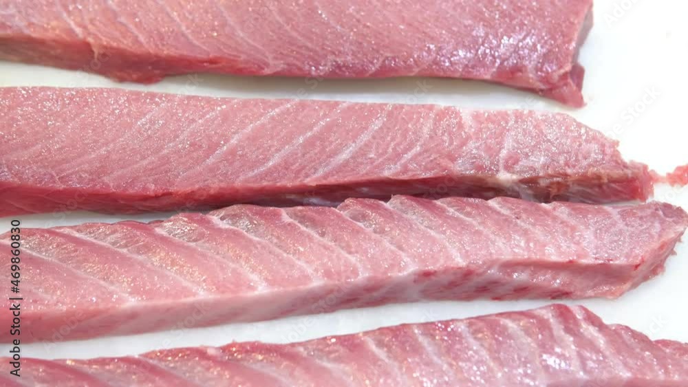 Two raw tuna slices steaks on plastic table Two raw tuna slices steaks on plastic table
