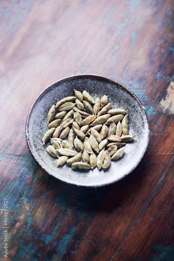 Green Cardamom Seeds on wooden background. Close up. Copy space. Green Cardamom Seeds on wooden background. Close up. Copy space.