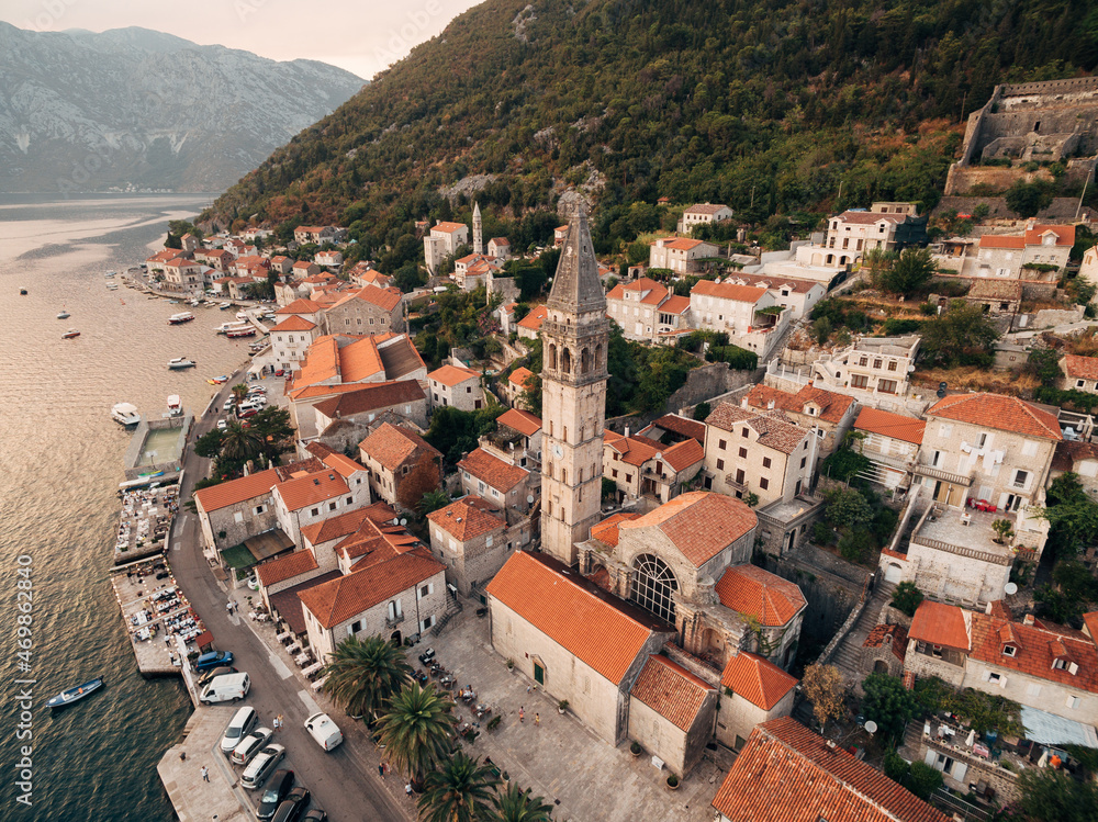 Bell tower among the old houses in Perast coast. Montenegro. Drone