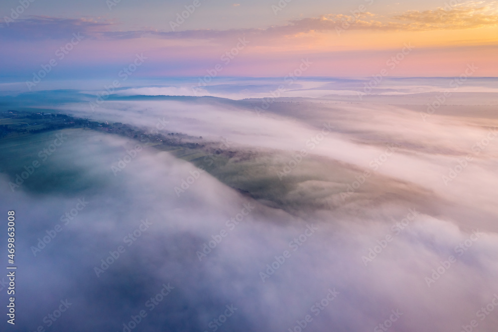 Fantastic scene of hills in the fog from a bird's eye view. Aerial photography, drone shot.