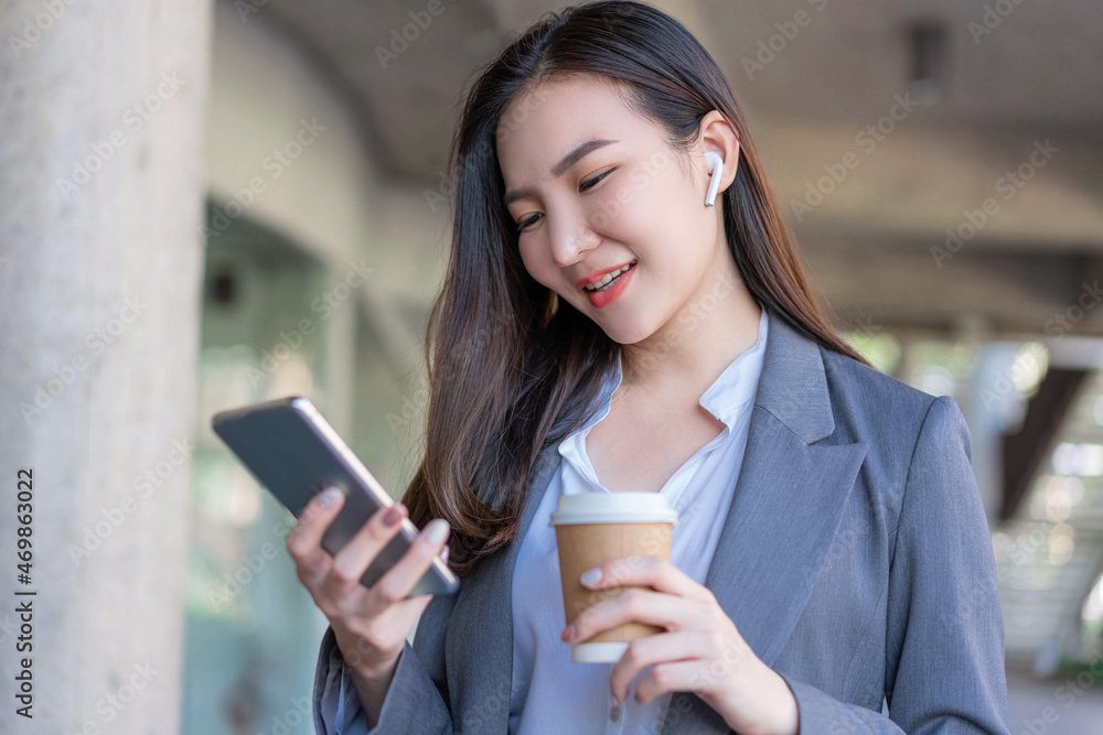 Working woman concept a young female manager holding a cup of coffee and communicating with the colleague via the video call Working woman concept a young female manager holding a cup of coffee and communicating with the colleague via the video call