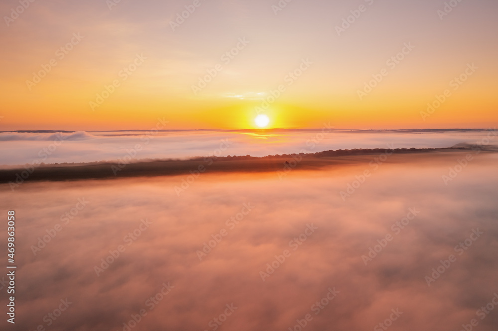 Picturesque scene of plain in the fog from a bird's eye view. Aerial photography, drone shot.