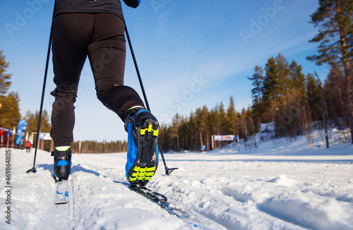 Winter sports competitions, back view boots and sticks cross of country skis glide on fresh snow