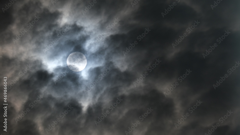 The beautiful full moon is shining with the white clouds in the sky at night in Bangkok, Thailand. The beautiful full moon is shining with the white clouds in the sky at night in Bangkok, Thailand.