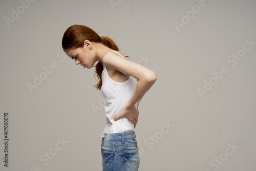 woman in white t-shirt chiropractic rheumatism health problems light background