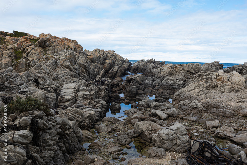 Rocky jagged coastline, rock pool and view out to the ocean Rocky jagged coastline, rock pool and view out to the ocean