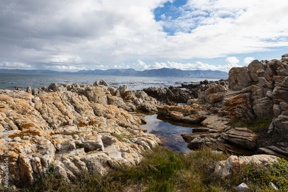 Rocky jagged coastline, rock pool and view out to the ocean Rocky jagged coastline, rock pool and view out to the ocean