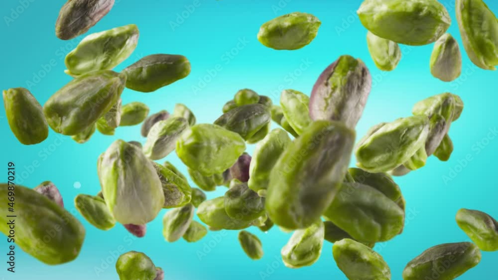 Flying of Peeled Pistachios in Ice Blue Background Flying of Peeled Pistachios in Ice Blue Background