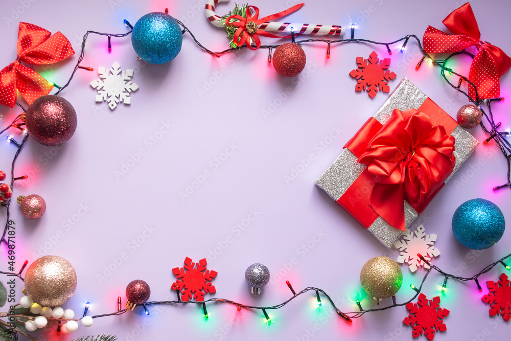Christmas lilac background with Christmas decorations and garland. The place for the text can be used as a template.